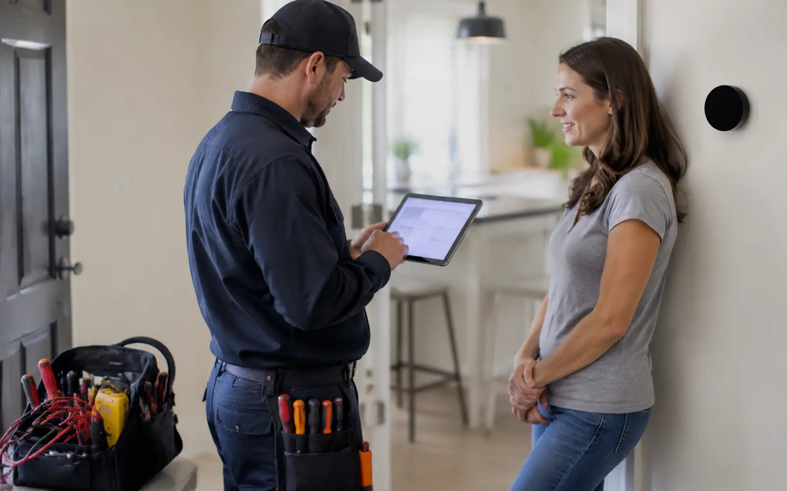 A field-service technician using digital tools in a real home-service environment.